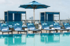 Outdoor pool with sun loungers and sun umbrellas at AC Hotel by Marriott Miami Beach, FL.