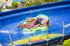 Two people sitting a double tube going down a blue waterslide at Adventure Island in Tampa, Florida.