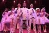 The cast of Anthems of Rock in white costumes onstage