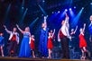 All the Array performers on stage in their bright blue and red evening wear as they do the finale of the show.