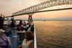 Guests sitting outside on the deck enjoying drinks and charring at sunset on the Signature Spirit of Baltimore Dinner Cruise.