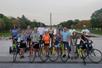 A group of tourist posing for a photo with their bikes on the National Mall with the Washington Monument in the background.