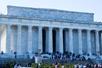 Wide shot of the Lincoln Memorial with several group of tourists on the steps and below them on an overcast day in Washington DC.