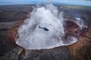 A Helicopter fling by the smoke that's pluming out of a crater of a volcano on Big Island's Circle of Fire Helicopter Tour in Hawaii USA.
