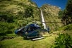 A helicopter parked in front of a waterfall. Big Island's Kohala Coast Adventure Helicopter Tour in Hawaii, USA.