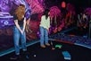 Guests golfing at Blacklight Mini Golf at American Dream in East Rutherford, NJ