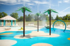 Outdoor pool area with a children's splash pad.