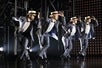 Bob Fosse's DANCIN' cast strike a pose wearing suites and beige hats.