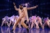 Bob Fosse's DANCIN' cast members dressed in salmon-colored suits on the Music Box Theatre stage in New York City.