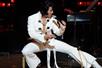 Bill Cherry in the white iconic Elvis costume performing on stage.