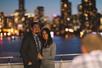 A couple psoing for a photo with the breathtaking views of Chicago’s skyline on their background on the Chicago Premier Dinner Cruise on Lake Michigan.