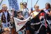 Several kids with face paint and other pirate accessories holding pirate flags on Sea Gypsy pirate ship on a sunny day.