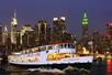 The Circle Line Harbor Lights Sightseeing Cruise at night with the city behind it in New York City, New York.