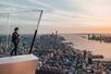 A woman enjoying the view off of the sky deck at sunset with the city in the distance at Edge New York.