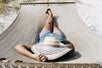 Guest lays in a hammock with a hat over their head