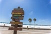 A wooden sign that points out attractions on the beach