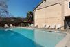 Seasonal outdoor pool with white lounge chairs lining the sides on a sunny day at Cloverdale Wine Country Inn & Suites.