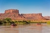 Some beautiful plateaues in the background while some guests raft down the Colorado River on the Colorado River Full-Day Rafting Adventure in Moab Utah.