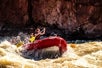 This girl is having a blast coming over this huge wave from the rapids they are encountering on the Colorado River Full-Day Rafting Adventure in Moab Utah.