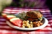 A plated meal of a hamburger, beans, pasts salad, and watermelon for lunch on the Colorado River Full-Day Rafting Adventure in Moab Utah.