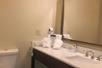 A hotel bathroom with a large mirror, sink and toilet at the Comfort Inn & Suites Ukiah Mendocino County.