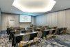 Meeting facility with tables, chairs and a large screen.