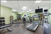 Fitness center with treadmill, free weights, and other gym equipment.