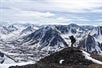 Photographer snaps a photo of the snowy mountain range on a guided Denali backcountry photo excursion