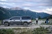 Two photographers standing to the right of the tour operator’s pickup truck/shuttle prepare to capture photos of Denali’s scenic mountain backdrop
