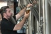A man pouring a beer into a glass at Frog Alley Brewing Company in Schenectady, New York