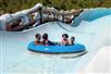 A family of four slide down Steamboat Springs in a blue tube on a sunny day at Disney's Blizzard Beach in Orlando, Florida, USA.