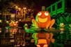 A jack o'lantern frog sitting on a lilypad in water with other frogs glowing behind it at night at Dollywood in Pigeon Forge, Tennessee, USA.