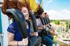 Young adults riding the Dominator and laughing on a sunny day at Dorney Park in Allentown, Pennsylvania.