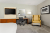 50-inch HDTV, work desk and arm chair inside a guest room at DoubleTree by Hilton Austin-University Area, TX. 