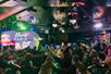 Wide shot of a crowd watching a queen with a large wig and neon outfit at Drag Brunch at Hamburger Mary’s Las Vegas.