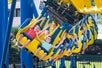 Several children raise their hands in excitement while riding the Merlin’s Mayhem suspension coaster at Dutch Wonderland in Lancaster, Pennsylvania.