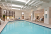 Refreshing indoor pool with poolside chairs.