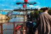 A man wearing a brown pirate hat steering the Queen Anne's Revenge ship on a sunny day with a blue sky overhead.