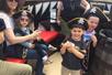 A family with three young children wearing pirate hats onboard the Queen Anne’s Revenge pirate ship.