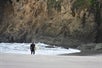 California coastline with a guest carrying a surfboard near Emerald Dolphin Inn.