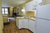 In-room kitchen refrigerator, stovetop, and microwave in a guest room.