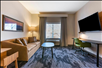 A seating area and a flat-screen TV inside a guest room.