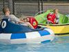 Two people are having fun with water bumper boats.