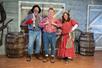 Three cast members in costume posing on stage at Funny Farm Dinner Feud in Branson, Missouri.