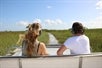 Two tourist aboard a boat while cruising through the Everglades Alligator Park with Go Miami & The Keys Explorer Pass.