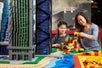 A mother and a child having fun playing with Legos indoors at Legoland Discovery Center Pennsylvania.