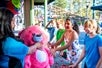 A staff at California's Great America giving out a pink stuff bear to several kids at a carnival game with Go San Francisco All-Inclusive Pass
