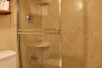 Glass enclosed shower inside a private bathroom at Gulfcoast Inn Naples, FL.