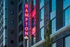 The exterior neon signage saying "HAMPTON" on the side of the Hampton Inn and Suites By Hilton Portland-Pearl District.