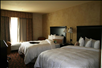 Two queen beds with plush beddings inside a guest room.